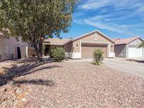 Single-story home with a low-maintenance rock yard, mature shade tree, and covered entrance at 30517 N Maple Chase Dr, San Tan Valley, AZ 85143