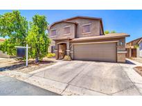 Two-story home featuring a two-car garage, a well-manicured lawn, and a charming front porch at 40638 N High Meadows Dr, San Tan Valley, AZ 85140