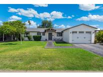 Charming single-story home with lush lawn, brick pathway, and attached two-car garage at 4842 E Fairmount Ave, Phoenix, AZ 85018