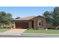 Charming single-story home featuring stone accents, a two-car garage and well manicured lawn at 4951 S 233Rd Dr, Buckeye, AZ 85326