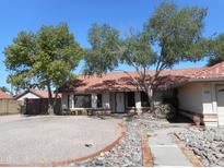 Charming single-story home with mature trees, tile roof, and easy to maintain rock landscaping at 1044 N Abner --, Mesa, AZ 85205
