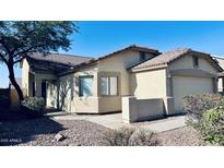 Tan home featuring a tile roof, two-car garage, and desert landscaping at 1630 W Pecan Rd, Phoenix, AZ 85041