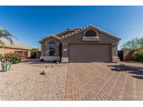 Charming single-story home featuring a brick driveway and low-maintenance desert landscaping at 18297 W Spencer Dr, Surprise, AZ 85374