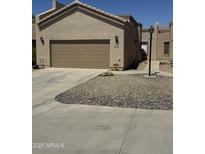 Beige home featuring a two-car garage and low maintenance desert landscaping at 18650 N 91St Ave # 1501, Peoria, AZ 85382