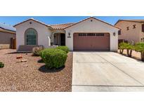 Charming single-story home features a well-maintained front yard with a two car garage and a tiled roof at 18669 W Vista Norte St, Goodyear, AZ 85338