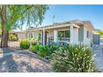 Inviting front porch with ample seating, lush plants, and stylish decor welcomes visitors at 2221 W Mitchell Dr, Phoenix, AZ 85015