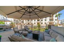 Spacious patio featuring an outdoor seating area, fire pit, and umbrella at 2511 W Queen Creek Rd # 166, Chandler, AZ 85248