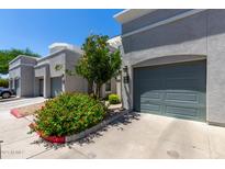 Contemporary townhouse exterior with gray facade, private garages, and colorful, mature landscaping at 295 N Rural Rd # 160, Chandler, AZ 85226