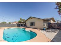 An inviting backyard pool is surrounded by ample patio space and landscaping, perfect for outdoor entertaining at 4238 W Krall St, Phoenix, AZ 85019