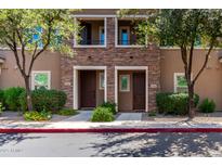 Inviting townhome showcasing a stone facade, well-maintained landscaping, and a private entryway at 5550 N 16Th St # 166, Phoenix, AZ 85016