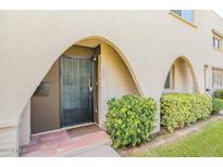 Charming front entrance with unique arched entryway and secure iron gate at 6945 E Osborn Rd # B, Scottsdale, AZ 85251