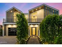 Stunning modern two-story home with meticulously manicured landscaping and a black-framed garage at 8038 E Clarendon Ave, Scottsdale, AZ 85251