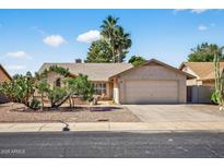 Charming single story home featuring a two car garage and mature desert landscaping at 9839 W Utopia Rd, Peoria, AZ 85382