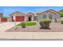 Charming single-story home featuring a red garage door and desert landscaping at 11306 E Rembrandt Ave, Mesa, AZ 85212
