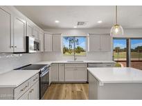 Bright kitchen features white cabinets, stainless steel appliances, and views to the backyard at 1236 S Boulder St # C, Gilbert, AZ 85296