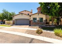 Beautiful home with neutral stucco, stone accents, two car garage, and mature landscaping at 3229 E Mountain Village Cir, Phoenix, AZ 85042