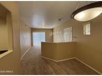 Spacious living area featuring neutral carpeting, lighting, and a sliding door at 3434 E Baseline Rd # 204, Phoenix, AZ 85042