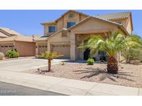 Inviting two-story home featuring a well-manicured front yard with mature palm trees and a three-car garage at 46141 W Rainbow Dr, Maricopa, AZ 85139