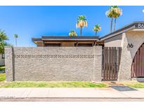 A charming home is adorned with decorative cinder block and a gated wooden fence entry, enhancing curb appeal at 830 S Dobson Rd # 86, Mesa, AZ 85202