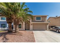 Two-story home with desert landscaping, attached two-car garage, and desert landscaping with palm trees at 8939 W Villa Rita Dr, Peoria, AZ 85382