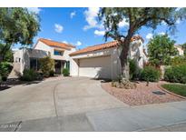 Charming home featuring a red tile roof and a two-car garage with well-maintained landscaping at 10068 E San Salvador Dr, Scottsdale, AZ 85258