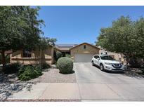Charming single-story home with desert landscaping, two-car garage, and solar panels at 10414 W Windsor Ave, Avondale, AZ 85392