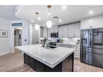 Modern kitchen features a large island with quartz countertop, stainless steel appliances, and pendant lighting at 120 E Rio Salado Pkwy # 101, Tempe, AZ 85281