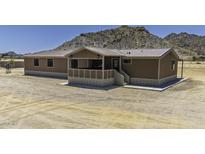 Inviting home with neutral siding, covered porch, and mountain backdrop at 13050 N Breeze Way, Maricopa, AZ 85139