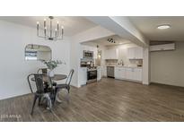 Open kitchen features stainless steel appliances, white cabinetry and a dining area at 1616 E Pecan Rd, Phoenix, AZ 85040