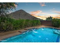 Inviting pool with a beautiful water feature and desert landscaping, set against a scenic mountain backdrop at 1812 E Parkside E Ln, Phoenix, AZ 85024
