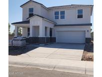 Two-story home featuring neutral stucco, stone accents, covered porch, and a two car garage at 2309 S 125Th Dr, Avondale, AZ 85323