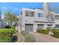 Modern townhouse showcasing a three-car garage and landscaped front yard on a sunny day at 7710 E Gainey Ranch Rd # 206, Scottsdale, AZ 85258