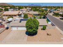 Expansive aerial view of a single-Gathering home featuring a two-car garage, solar panels, and a lush front yard at 823 N 81St St, Mesa, AZ 85207