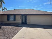 Charming single-story home with a well-maintained front yard and a two-car garage at 945 W Mendoza Ave --, Mesa, AZ 85210