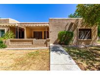 Inviting front exterior featuring a covered patio, neutral stucco, and desert landscaping at 14300 W Bell Rd # 6, Surprise, AZ 85374