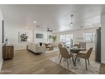 Open-concept living room with modern furnishings and decor and adjacent dining space at 16421 N 34Th Ave, Phoenix, AZ 85053