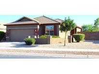 Charming single-story home with desert landscaping, tan stucco and brick accents at 21433 E Calle De Flores Ct, Queen Creek, AZ 85142