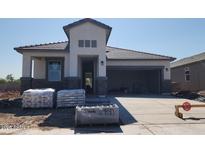 Craftsman style home with stone accents, a two-car garage, and a covered porch under construction at 2317 S 125Th Dr, Avondale, AZ 85323
