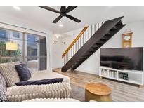 Bright living room features modern ceiling fan, wood floors, and open staircase at 2946 N 14Th St # 3, Phoenix, AZ 85014