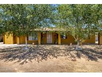 Charming single-story home with mature trees providing shade in the front yard at 3842 W Ocotillo Rd, Phoenix, AZ 85019