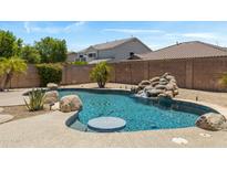 Inviting pool with rock waterfall feature surrounded by desert landscaping in a private backyard setting at 4093 E Westchester Dr, Chandler, AZ 85249