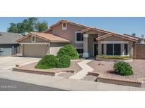 Charming two-story home featuring a well-manicured yard, a two-car garage, and a welcoming entrance at 5596 W Mercer Ln, Glendale, AZ 85304