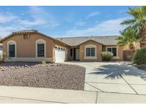 Charming single-story home with a well-manicured yard and a long driveway leading to a two-car garage at 909 E Harwell Rd, Phoenix, AZ 85042