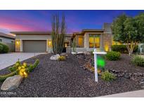 Beautifully landscaped front yard with desert plants, rock features, and modern home facade at dusk at 11796 W Creosote Dr, Peoria, AZ 85383