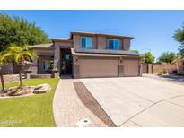 Charming two-story home featuring a three-car garage, desert landscaping, and a paver walkway at 1204 S Arroya Cir, Mesa, AZ 85206