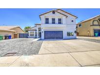 Two story home with a white exterior, desert landscaping, a two car garage and a gray brick driveway at 1853 N Rowen Cir, Mesa, AZ 85207