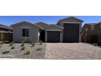 Charming single-story home featuring a brick driveway, desert landscaping, and a two-car garage at 18661 E Helian Dr, Gold Canyon, AZ 85118