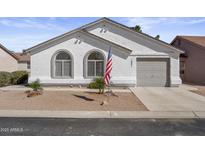 Charming single-story home featuring a two-car garage, arched windows, and neat desert landscaping at 1881 E Kerby Farms Rd, Chandler, AZ 85249