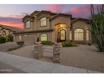 Elegant two-story home with a three-car garage and desert landscaping, illuminated by a vibrant sunset sky at 1935 E Seminole Dr, Phoenix, AZ 85022