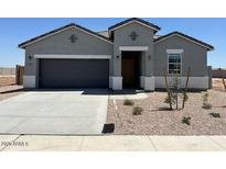 A charming single-story home with a gray exterior, a two-car garage, and well-maintained landscaping at 38105 W Bello Ln, Maricopa, AZ 85138